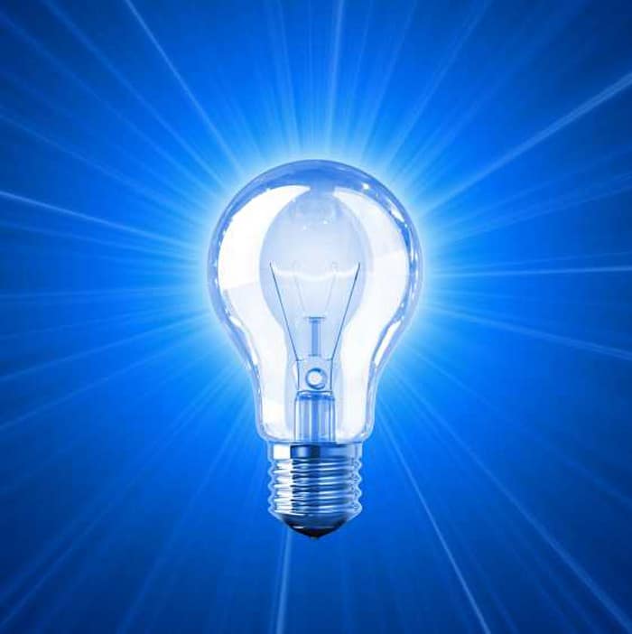 incandescent light bulb illuminating blue background rays extending