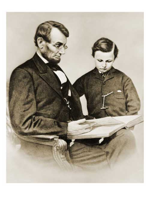 president abraham lincoln seated reading book son tad white house black and white