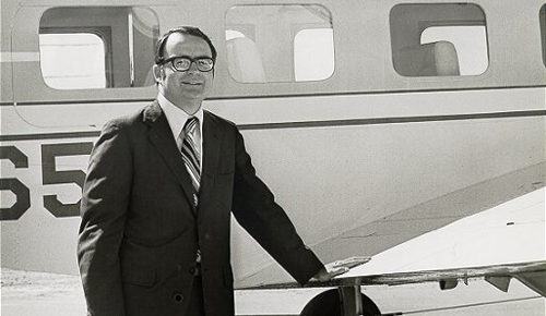 william ruckelshaus standing black and white outside small plane