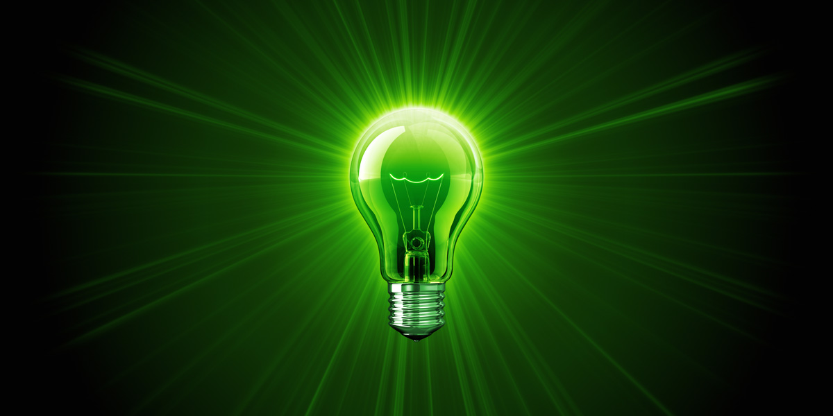 green incandescent light bulb illuminating green background with rays of light @servetolead.com